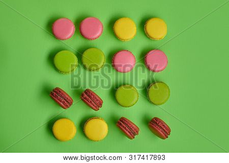 Colored Macaron Or Macaroon, Sweet Meringue-based Confection On Green Background. Close-up, Copy Spa