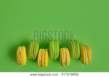 Colored Macaron Or Macaroon, Sweet Meringue-based Confection On Green Background. Close-up, Copy Spa