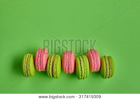 Colored Macaron Or Macaroon, Sweet Meringue-based Confection On Green Background. Close-up, Copy Spa