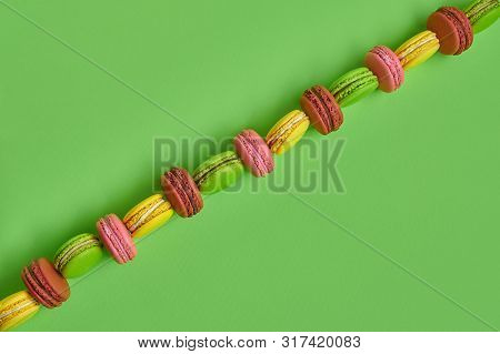 Colored Macaron Or Macaroon, Sweet Meringue-based Confection On Green Background. Close-up, Copy Spa