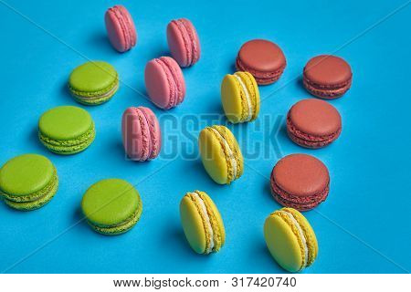 Colored Macaron Or Macaroon, Sweet Meringue-based Confection On Blue Background. Close-up, Copy Spac