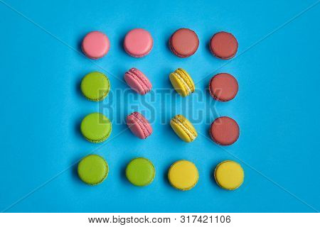 Colored Macaron Or Macaroon, Sweet Meringue-based Confection On Blue Background. Close-up, Copy Spac