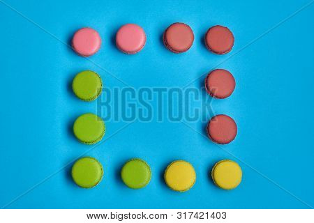 Colored Macaron Or Macaroon, Sweet Meringue-based Confection On Blue Background. Close-up, Copy Spac