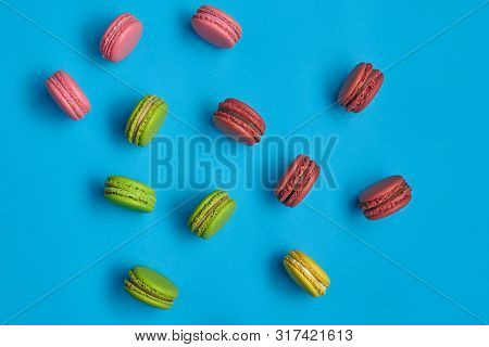 Colored Macaron Or Macaroon, Sweet Meringue-based Confection On Blue Background. Close-up, Copy Spac