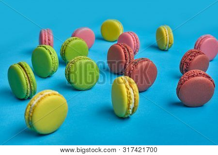 Colored Macaron Or Macaroon, Sweet Meringue-based Confection On Blue Background. Close-up, Copy Spac