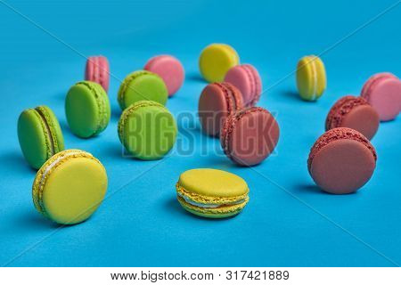 Colored Macaron Or Macaroon, Sweet Meringue-based Confection On Blue Background. Close-up, Copy Spac