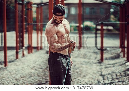 Fitness Man Exercising With Stretching Band. Muscular Sports Man Exercising With Elastic Rubber Band