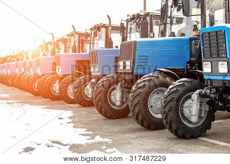 Many Different Tractors Standing In Row At Agricultural Fair For Sale Outdoors.equipment For Agricul