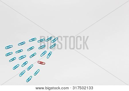 A Bunch Of Blue Paperclips Aligned And One Red Paperclip Nonaligned On White Background , Shot From