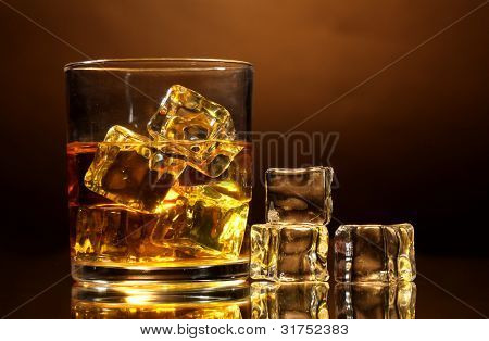 verre de whisky et de la glace sur fond marron