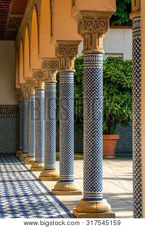 Oriental Looking Columns With Blue Mosaic Pattern And A Tiled Floor With Oriental Patterns
