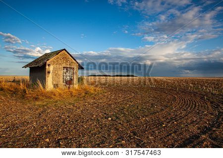 Old Barn And Empty Field After Harvesting In Sunny Day. Old Barn  With Mowed Wheat Field  Under  Sun