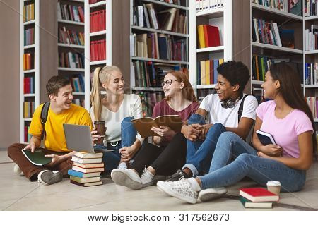 Group Of International Tennage Friends Having Conversation While Preparing For School Exams, Library