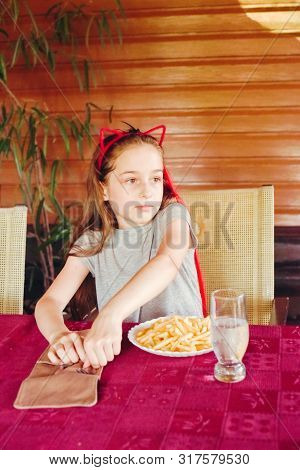 The Child Eats And Drinks Water. Little Girl Eats French Fries. Girl In Hoop Cat Ears. Red Lock Of H