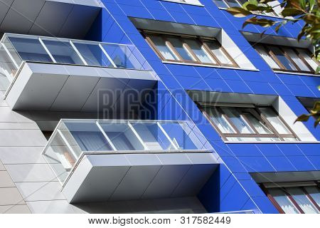 Photo Of A Buolding Detail With Several Windows, Soft Colours And Sunlight.