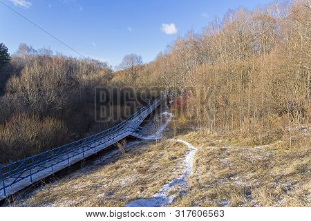 Late Autumn, End Of  November. A Small Ravine With A Footbridge Covered With The First Snow. Landsca