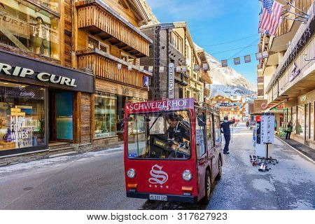 Zermatt, Switzerland - April 11, 2018: Unidentified Man Drives Electric Delivery Car By The Main Str