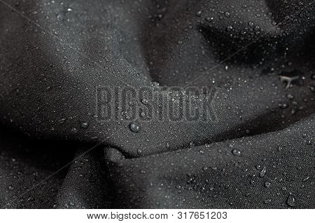 Dark Gray Waterproof Hydrophobic Cloth Closeup With Rain Drops Selective Focus Background