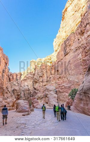 Petra, Jordan - October 13, 2018: Tourists In Narrow Passage Of Rocks Of Petra Canyon In Jordan. Pet