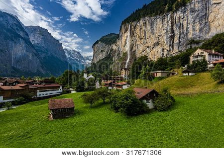 Famous View Of Lauterbrunnen Town In Swiss Alps Valley With Gorgeous Staubbach Waterfalls In The Bac