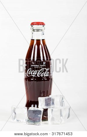 London, United Kingdom, 16th August 2019:- A Coca-cola Glass Bottle With Ice. Contains 10.6g Of Suga