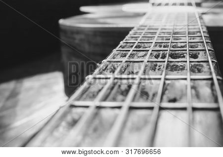 Perspective Photo Of The Neck Of An Old Acoustic Guitar And The Body Unfocused On The Background. Fo