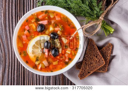 Traditional Russian Meat Soup Solyanka In Bowl On Rustic Wooden Table