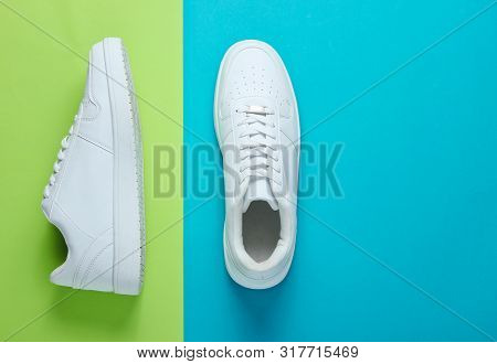 Fashionable White Sneakers On A Two-tone Background. Top View