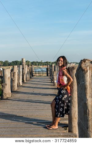 Vertical Picture Of Beautiful Asian Eye Model Smiling At U Bein Bridge, A Landmark Of Mandalay, Myan