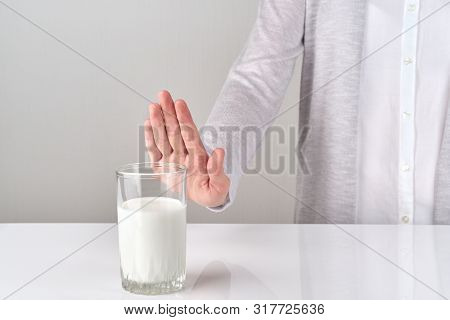 A Stop Sign To Glass Of Milk From Woman On White And Gray Background