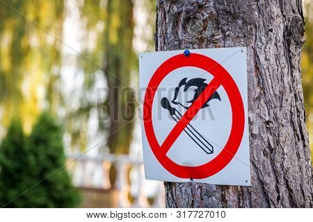 No Match Fire Sign. Red Circle With Crossed Match. Blurred Park Nature Background. Prohibition Of Li