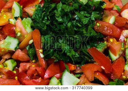 Multi-layered Vegetable Salad With Hazelnuts On A Blue Dish On A Blue Tablecloth With A Pattern