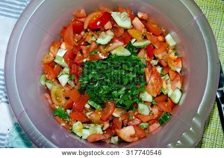 Multi-layered Vegetable Salad With Hazelnuts On A Blue Dish On A Blue Tablecloth With A Pattern