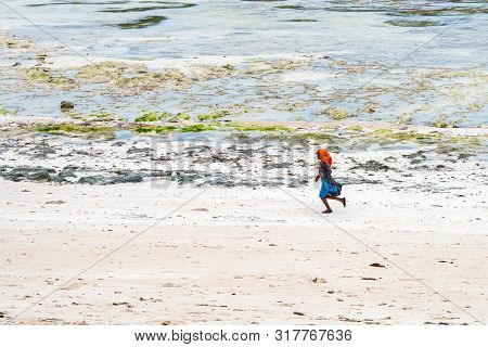 Stown Town, Tanzania - 11 January 2015: Local Girl Walks On Coast In Zanzibar