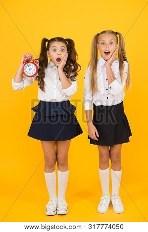 School Time. Surprised Shocked Kids Hold Alarm Clock Counting Time. Latecomer Will Be Punished. It I