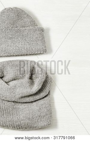 Woolen Knitted Clothing, Wool Cap And Scarf. Warm Womans Winter Clothes On White Wooden Background. 