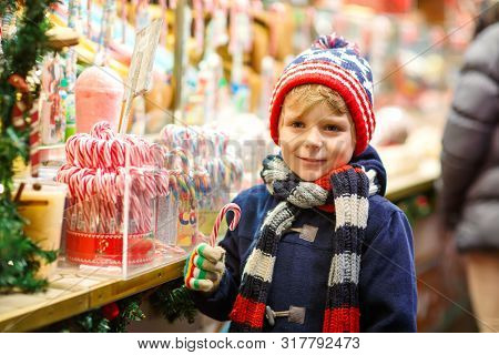 Little Cute Kid Boy Buying Sweets From A Cancy Stand On Christmas Market. Happy Child On Traditional