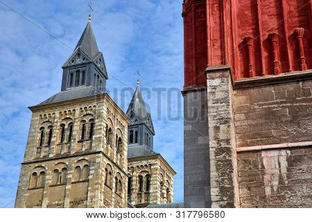 The Clock Towers Of Basilica Of Saint Servatius, Located At Vrijthof, With The Colorful Sint Jansker