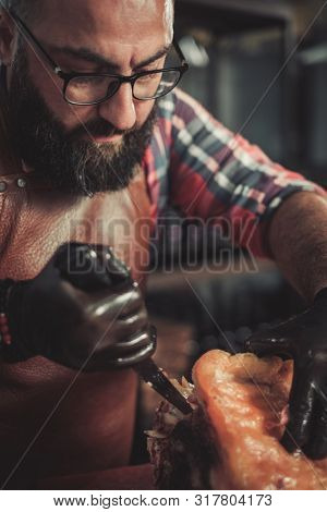 Chef cutting beef carcass in a restaurant