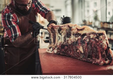 Chef cutting beef carcass in a restaurant