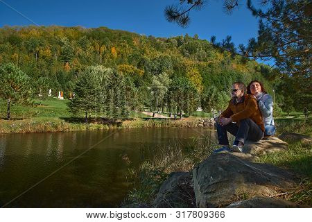 Couple Of Tourists By The Lake Enjoy Nature In A Buddhist Temple In Quebec On A Sunny Day
