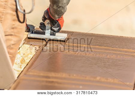 Construction Worker Using Hand Groover On Wet Cement Forming Coping Around New Pool.