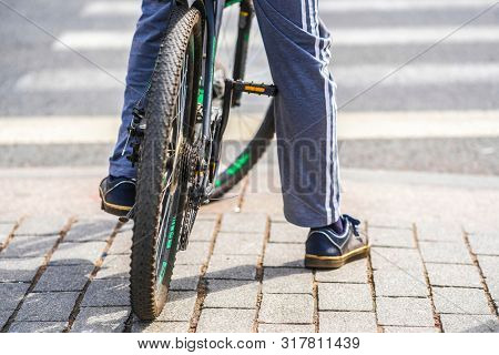 Saint Petersbourg, Russia - August, 14, 2019: Bicyclist waiting on a pedestrian crossroad in Saint Petersbourg