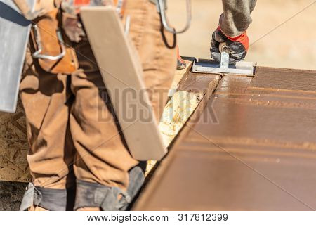 Construction Worker Using Hand Groover On Wet Cement Forming Coping Around New Pool.