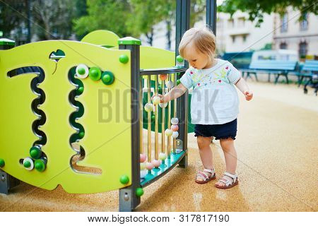 Adorable Toddler Girl Having Fun On Playground. Outdoor Activities For Kids