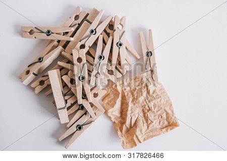 Woodenl Clothespins, Paper Clip And Brown Sticker On White Background. Isolated On White. View From 