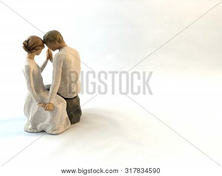 The Figure Of A Couple In Love. The Statuette He And She - Love. A Man And A Woman Are Sitting, Hugg