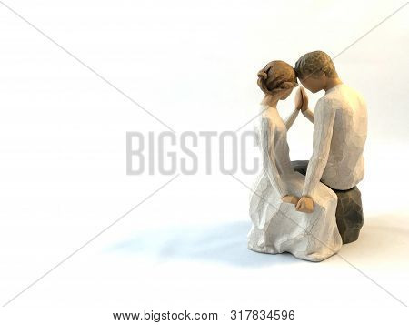The Figure Of A Couple In Love. The Statuette He And She - Love. A Man And A Woman Are Sitting, Hugg