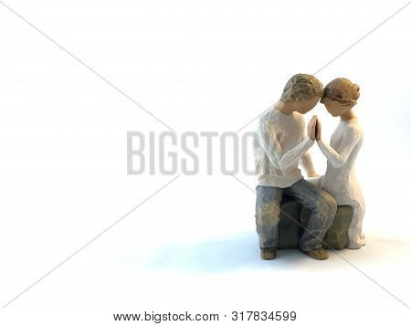 The Figure Of A Couple In Love. The Statuette He And She - Love. A Man And A Woman Are Sitting, Hugg
