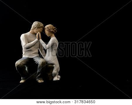 The Figure Of A Couple In Love. The Statuette He And She - Love. A Man And A Woman Are Sitting, Hugg